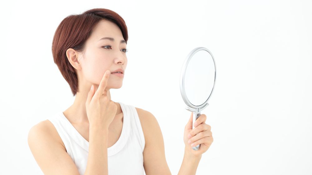 手鏡で口を見る女性